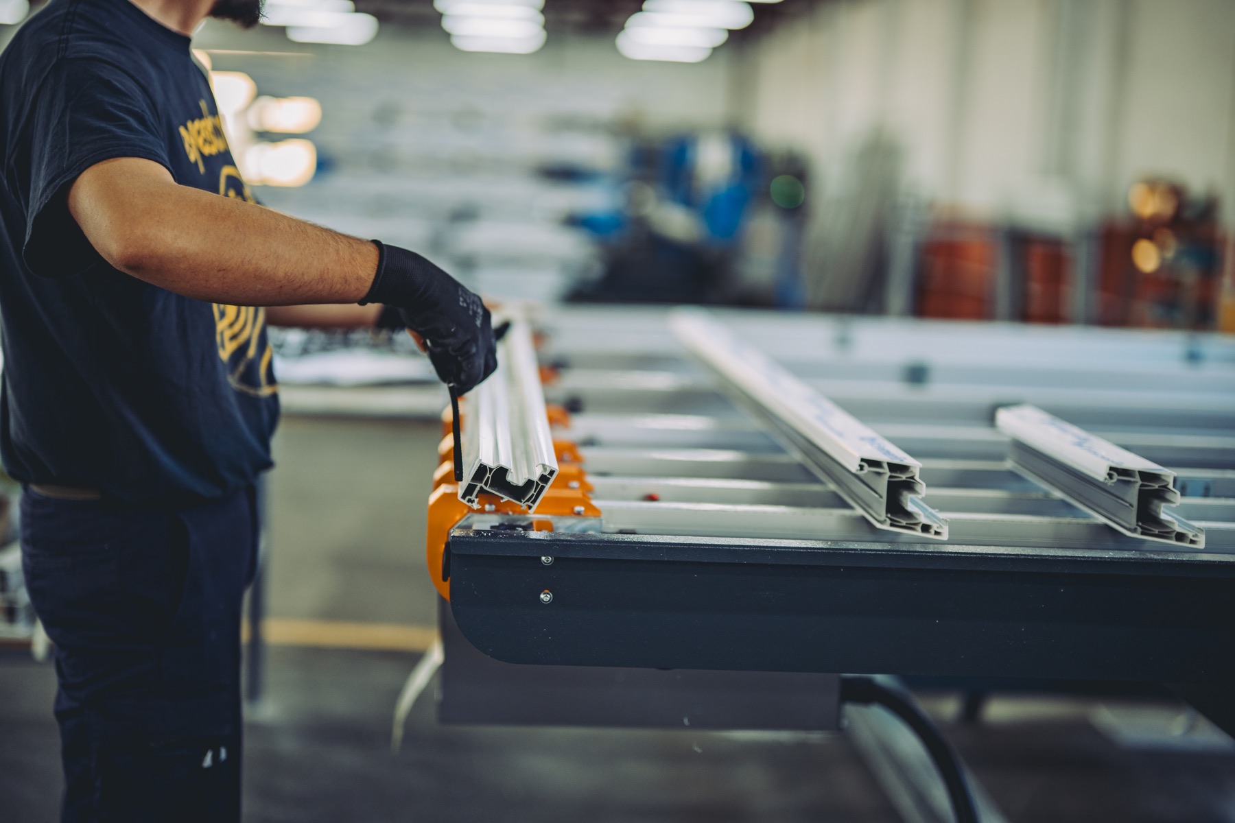 A factory technician working with metal profiles